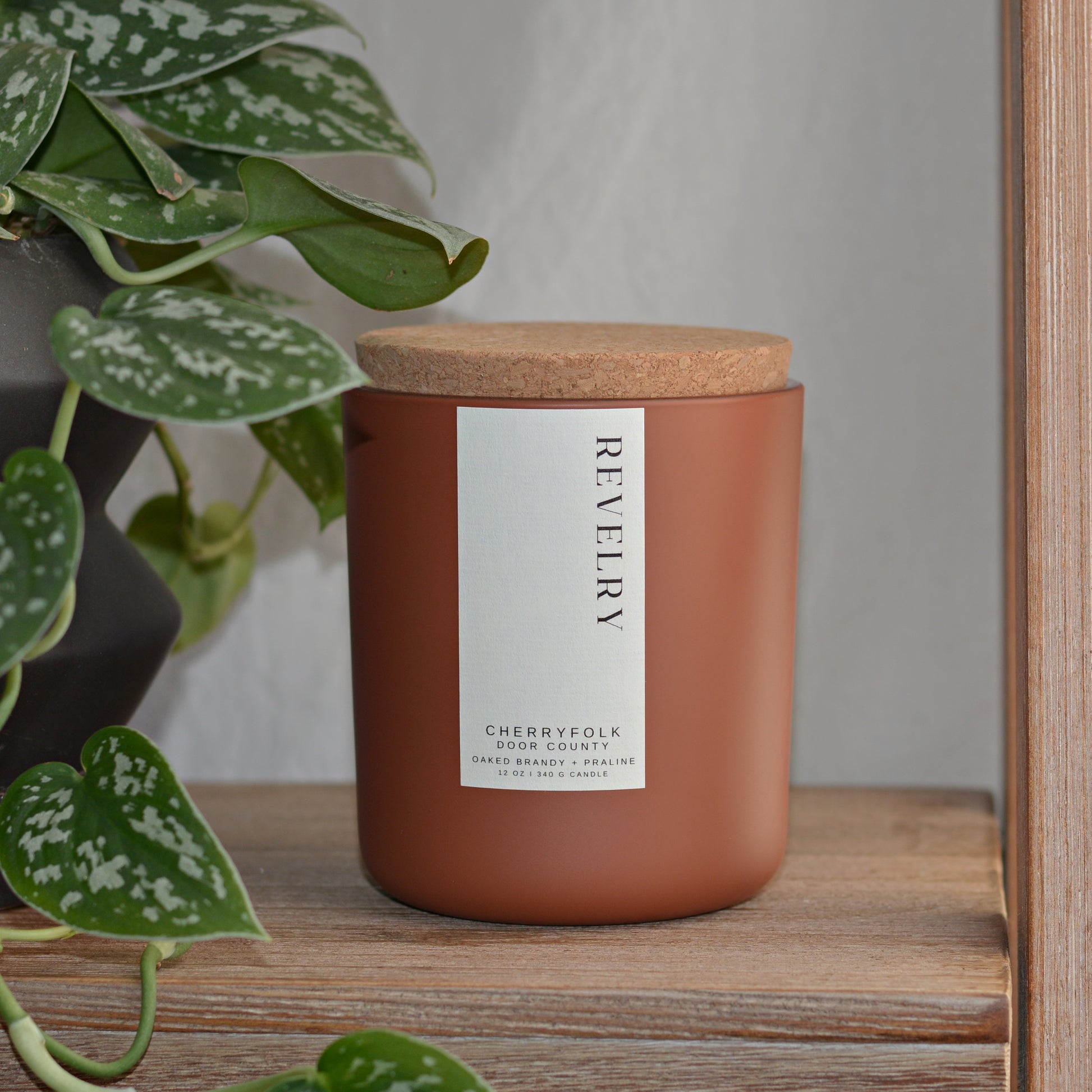 a handmade scented candle in clay colored matte glass with a cork lid